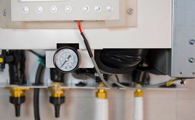pressure gauge on a heating system with five connecting valves and pipes